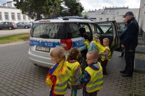 Policjanci prowadzą spotkanie z dziećmi .