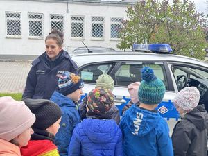 Policjantka prezentuje dzieciom radiowóz