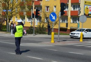 Policjant kieruje ruchem na skrzyżowaniu drogi K 6 z ul. 12-go Marca w Wejherowie.