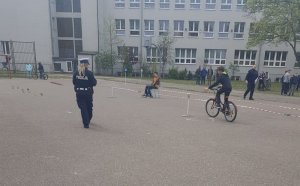 Policjantka egzaminuje uczniów na torze przeszkód.