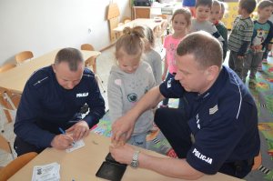 Policjanci prowadzą zajęcia profilaktyczne z dziećmi.