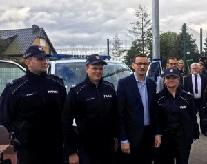 Policjanci na wspólnym zdjęciu z Premier Mateuszem Morawiecki przy radiowozie VW t6