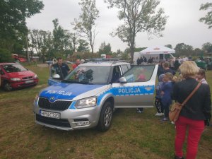 Policjanci na festynie rozmawiają o bezpieczeństwie, rozdają odblaski.