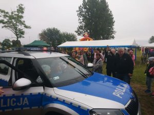 Policjanci prezentują policyjny radiowóz.