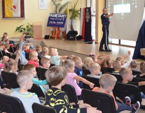 Policjantka prowadzi zajęcia z uczniami na temat bezpieczeństwa.