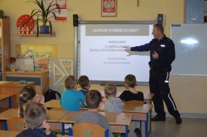 Policjanci prowadzą zajęcia edukacyjne z dziećmi i tłumaczą zasady bezpieczeństwa