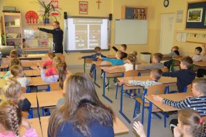 Policjanci prowadzą zajęcia edukacyjne z dziećmi i tłumaczą zasady bezpieczeństwa