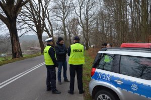 Policjanci w Kostkowie sprawdzają infrastrukturę drogową w miejscu wypadku.