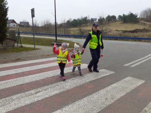 Dzielnicowa przeprowadza dzieci przez jezdnię