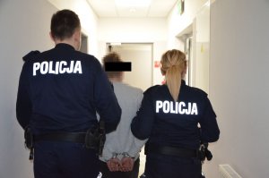 Policjanci prowadzą zatrzymanego mężczyznę