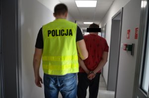 Policjant prowadzi zatrzymanego