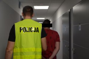 Policjant prowadzi zatrzymanego