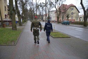 Policjant wspólnie z funkcjonariuszem Żandarmerii Wojskowej patroluje miasto.