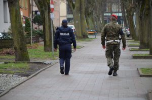 Policjant wspólnie z funkcjonariuszem Żandarmerii Wojskowej patroluje miasto.