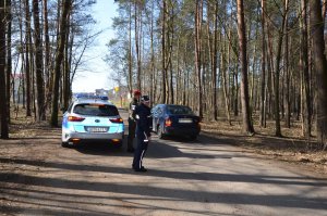 Patrol policjant i funkcjonariusz Żandarmerii Wojskowej kontrolują drogi prowadzące do lasu