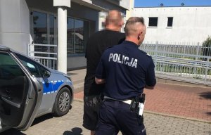 Policjant prowadzi zatrzymanego