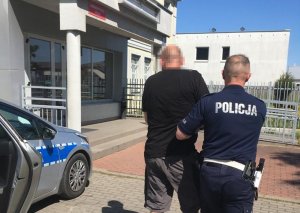 Policjant prowadzi zatrzymanego