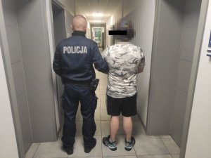 Policjant prowadzi zatrzymanego