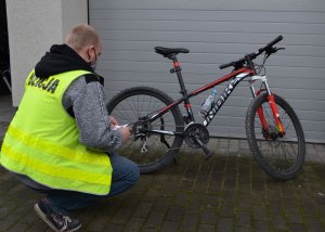 Policjant wykonuje oględziny kradzionego roweru