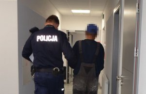 Policjant prowadzi zatrzymanego