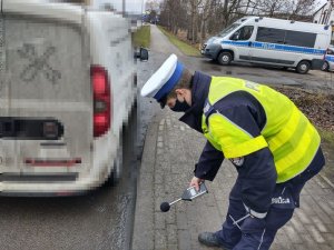 Policjant urządzeniem pomiarowym bada głośność w samochodzie