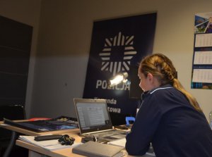 Policjantka siedzi przed komputerem i prowadzi lekcję on-line