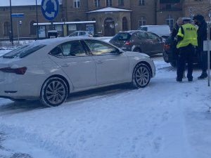 Policjanci pracują na miejscu kolizji drogowej przy Komendzie Powiatowej Policji w Wejherowie. Samochody uczestniczące w kolizji stoją na chodniku. Policjant rozmawia z uczestnikami kolizji.