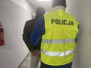 Policjant prowadzi zatrzymanego