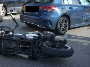 Na pierwszym planie widoczna jest połowa leżącego motocykla na jezdni, a tuż za nim mercedes, z którym doszło do zderzenia.