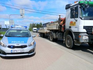 Radiowóz został zaparkowany równolegle po lewej stronie samochodu ciężarowego.