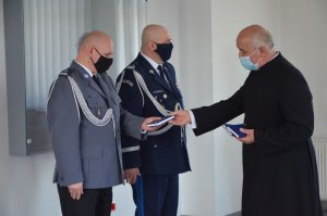 Ksiądz Prałat gratuluje Komendantowi Powiatowemu Policji w Wejherowie.