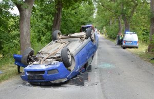 Samochód leży na dachu, w tle widać policyjny radiowóz