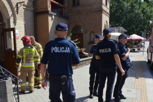 Policjanci zabezpieczają teren dworca PKP, w tle widać strażaków