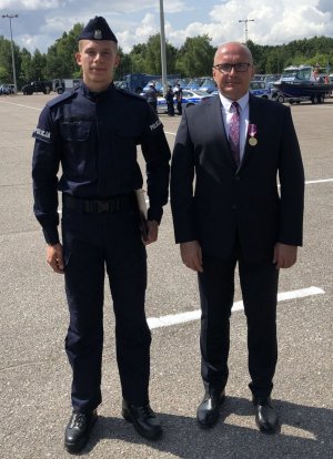 Policjant stoi razem z mężczyzną w garniturze