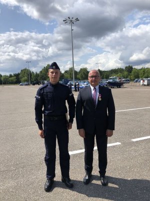 Policjanci stoi razem z mężczyzną w mundurze.