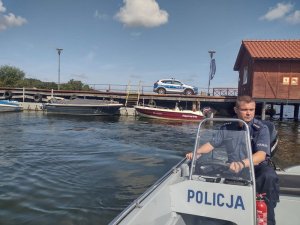 Policjant na motorówce pływa przy nabrzeżu