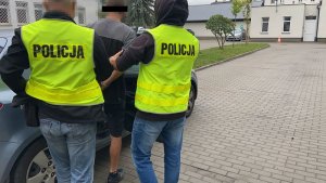 Policjanci prowadzą zatrzymanego