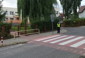 Policjant patroluje rejon przy szkole.