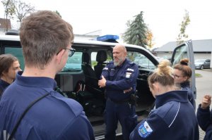 Policjant prezentuje policyjny radiowóz.