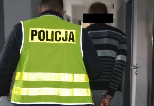 Policjant prowadzi zatrzymanego