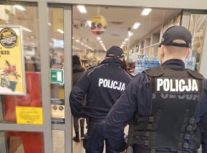 Policjanci wchodzą do sklepu na kontrolę