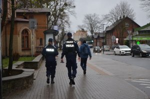 Policjanci idą w kierunku dworca PKP w Wejherowie.