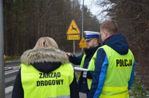 Policjant ruchu drogowego, zarządca drogi oraz policjant dochodzeniowo śledczy rozmawiają na miejscu zdarzenia.