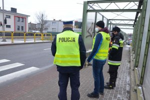 Komisja w składzie Policjanta w umundurowaniu ruchu drogowego, policjanta w ubiorze cywilnym w kamizelce odblaskowej oraz strażaka i zarządca drogi rozmawiają na chodniku, przy ekranach energochłonnych przy wejściu na przejście dla pieszych.