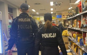 Policjanci chodzą między regałami.