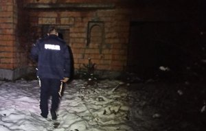 Policjant wchodzi do ciemnego pomieszczenia w opuszczonym budynku, który nie został do końca zbudowany.