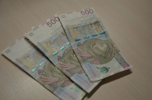 Trzy banknoty pięciuset złotowe rozłożone na biurku.