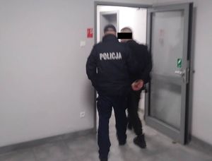 Policjanci prowadzą zatrzymanego.