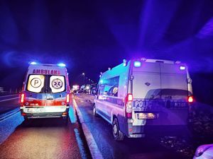 Na drodze stoi na sygnałach świetlnych karetka oraz policyjny radiowóz.