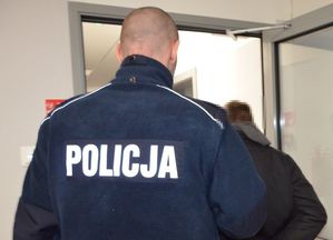 Policjant prowadzi zatrzymanego